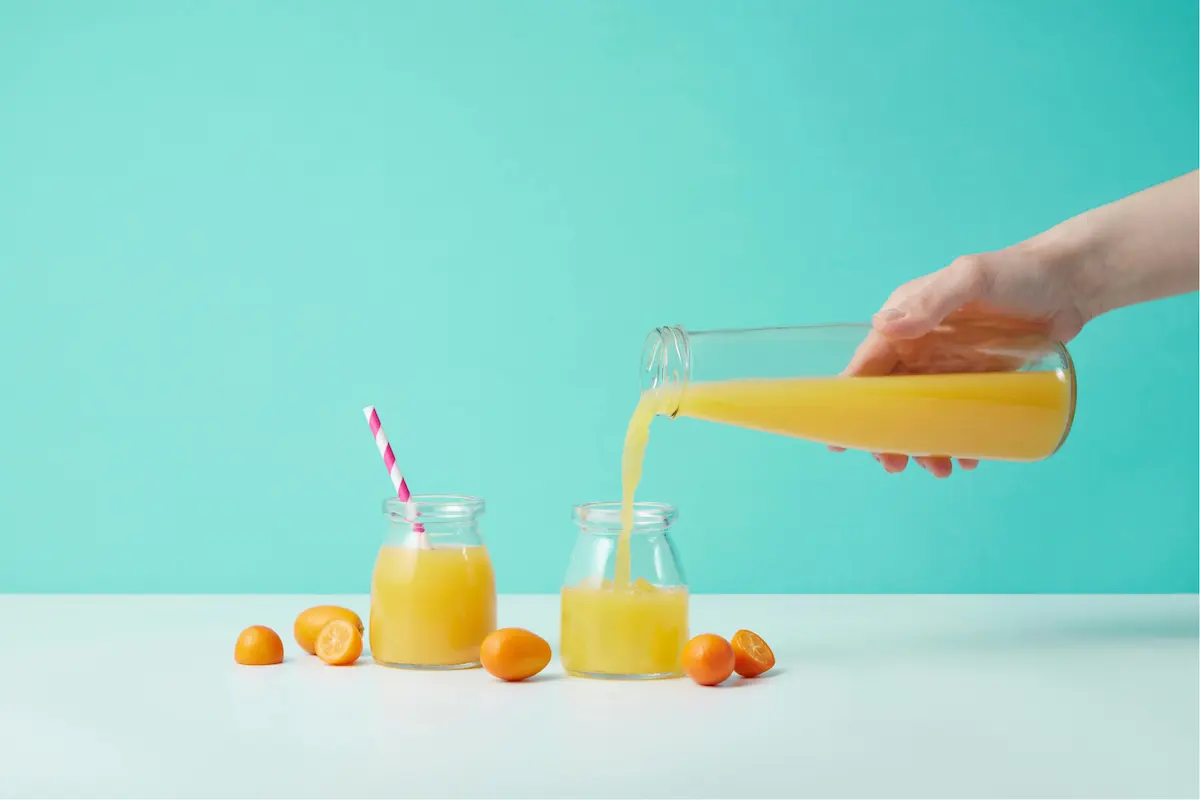 image showing hand pouring juice in bottle