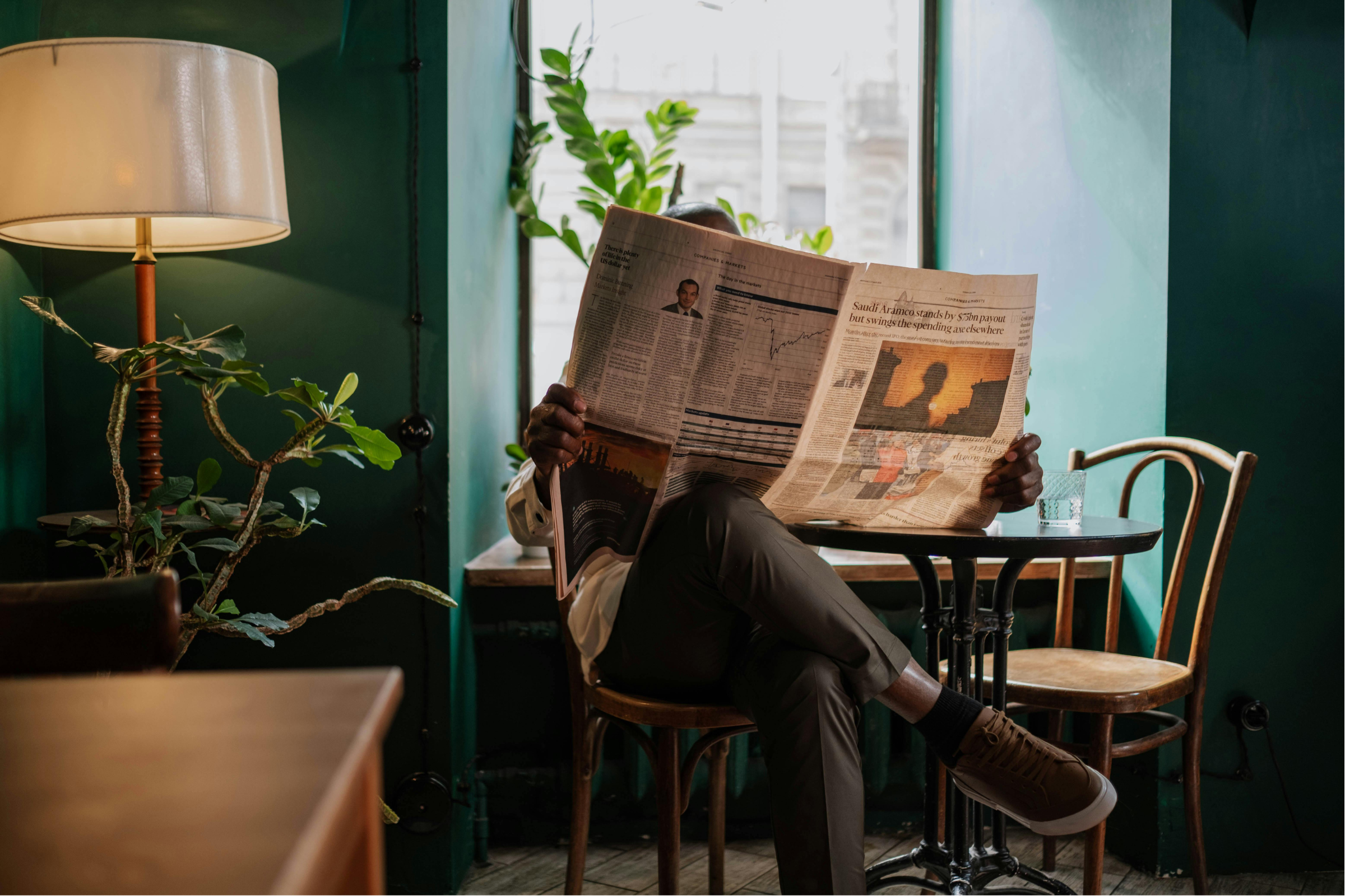 showing person sitting and reading newspaper